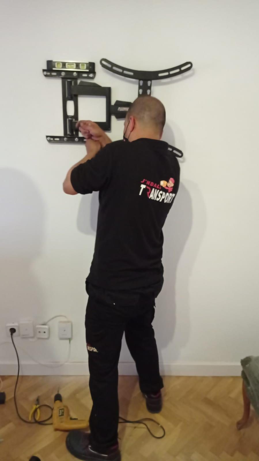 Técnico J'Ndali instalando un soporte de televisión